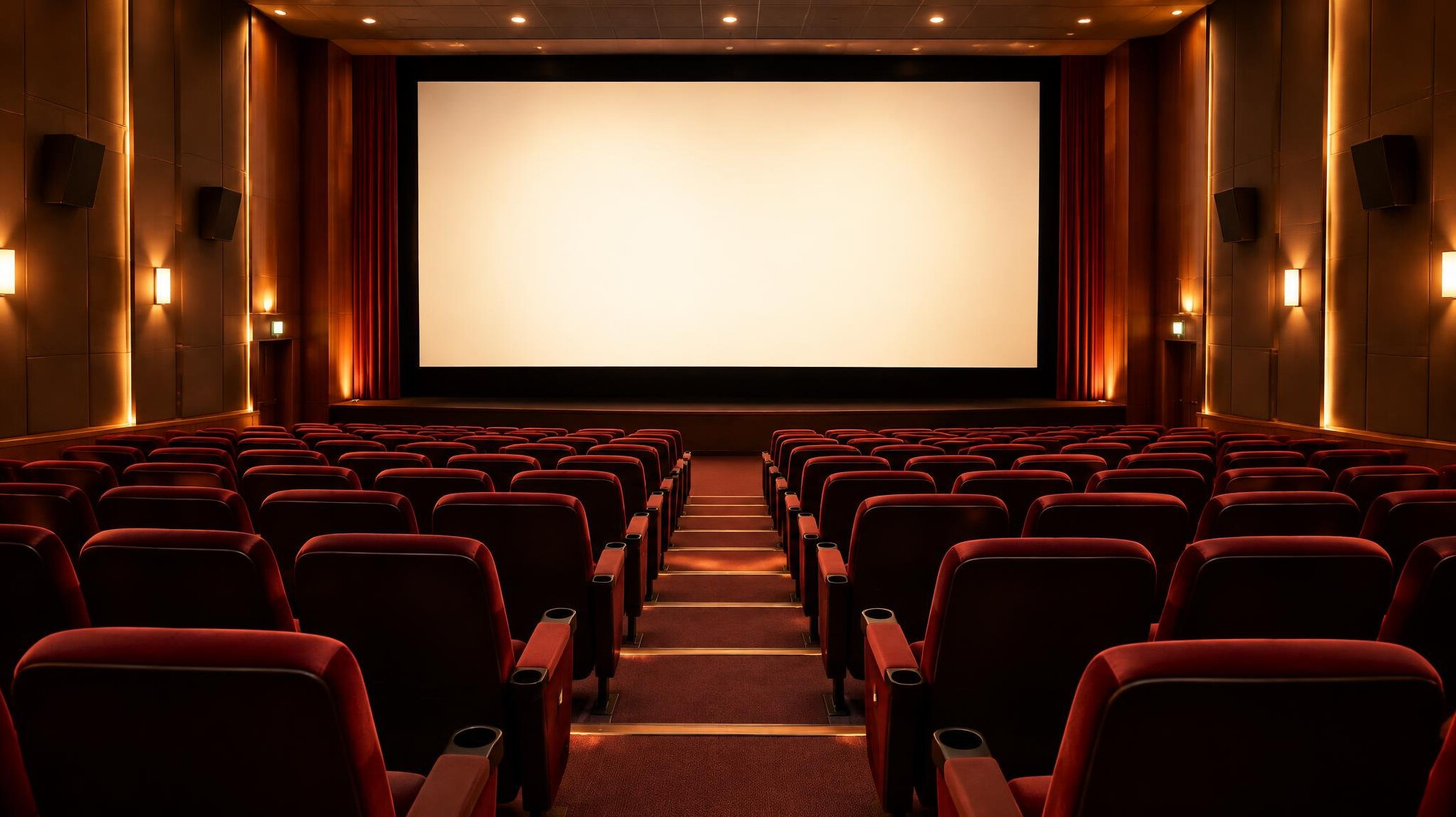Cinema interior with red seats and a large screen
